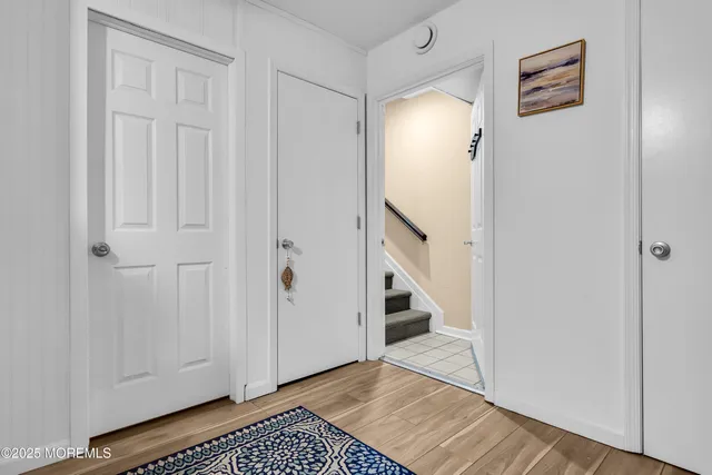 a view of a hallway with wooden floor and cabinets
