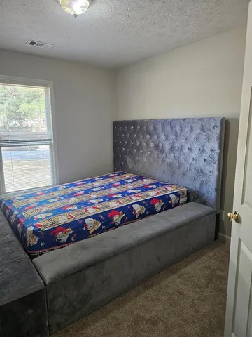 a bedroom with a bed and window