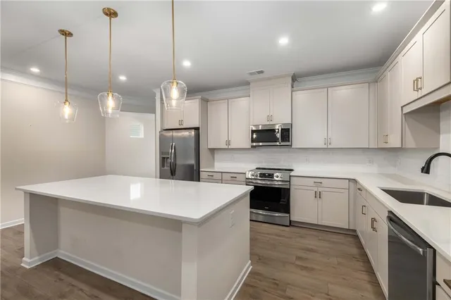 a kitchen with kitchen island a sink stainless steel appliances and cabinets
