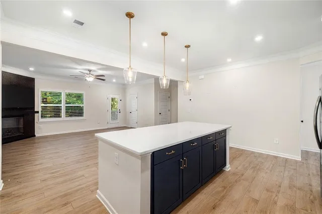 a large kitchen with a wooden floor and a hallway