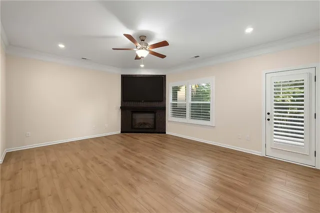 a view of an empty room with a window and wooden floor