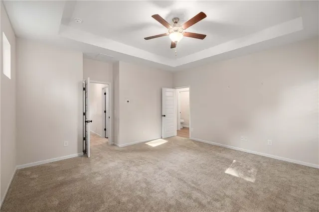 an empty room with a ceiling fan and a window
