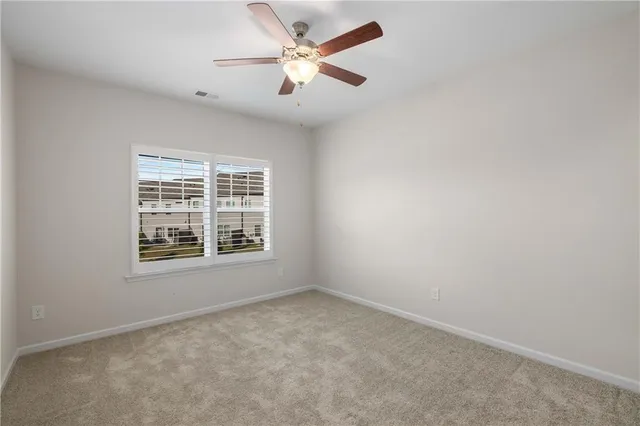 an empty room with a window and a fan