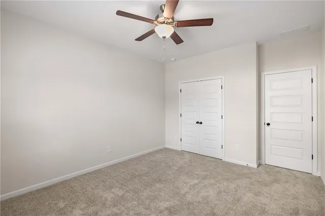 an empty room with chandelier fan