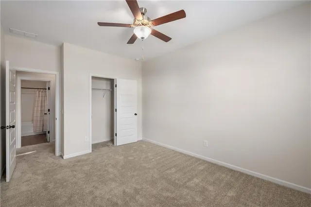 an empty room with a ceiling fan and a fan