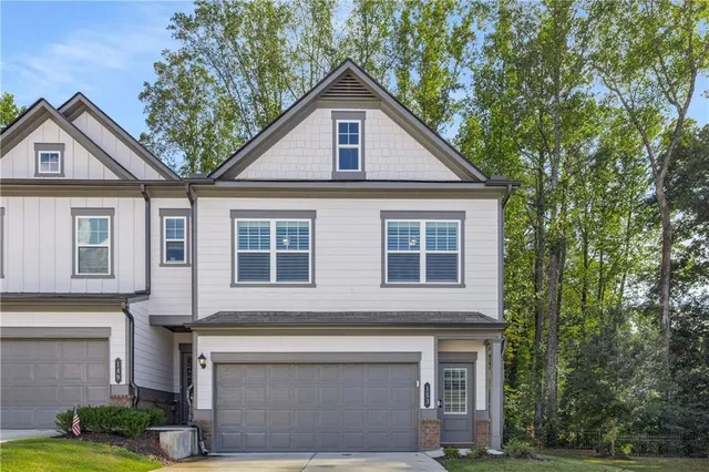 a front view of a house with garage and yard