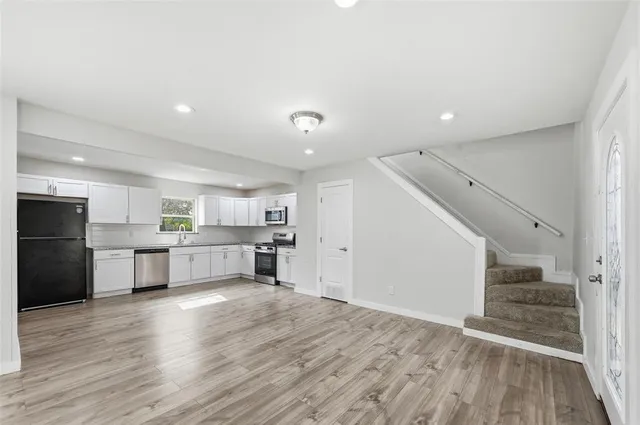 a kitchen with a refrigerator and white cabinets