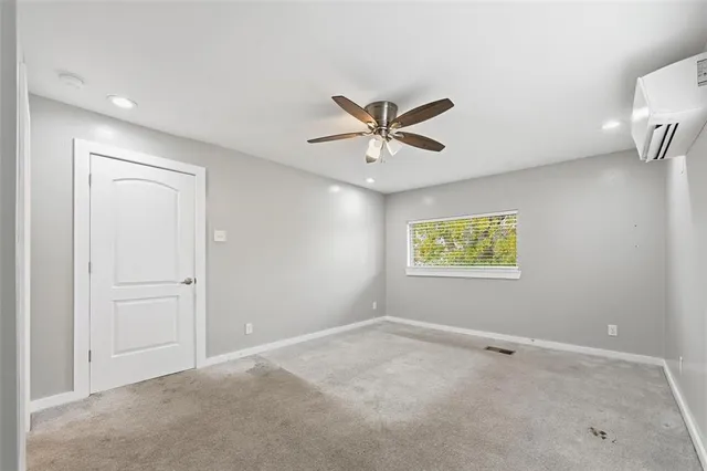 an empty room with a window and a ceiling fan