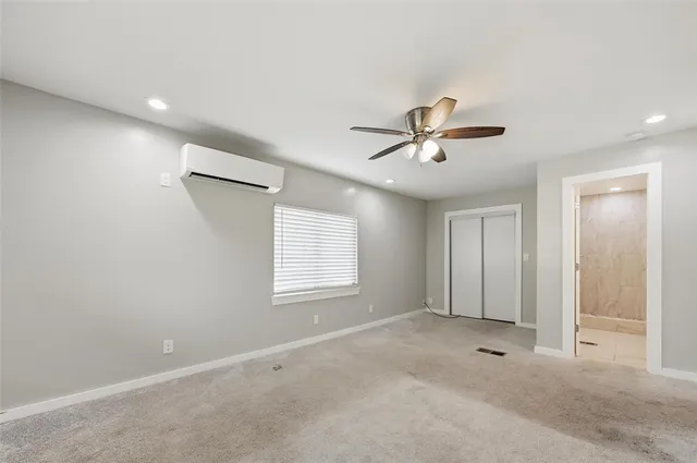 a view of a livingroom with a ceiling fan & windows