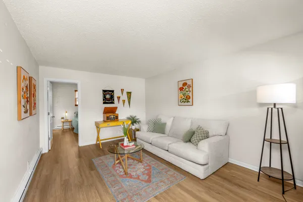 a living room with furniture and a wooden floor