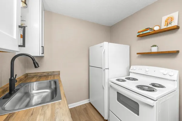 a kitchen with a refrigerator sink and stove