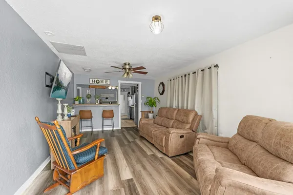 a living room with furniture a rug and white walls