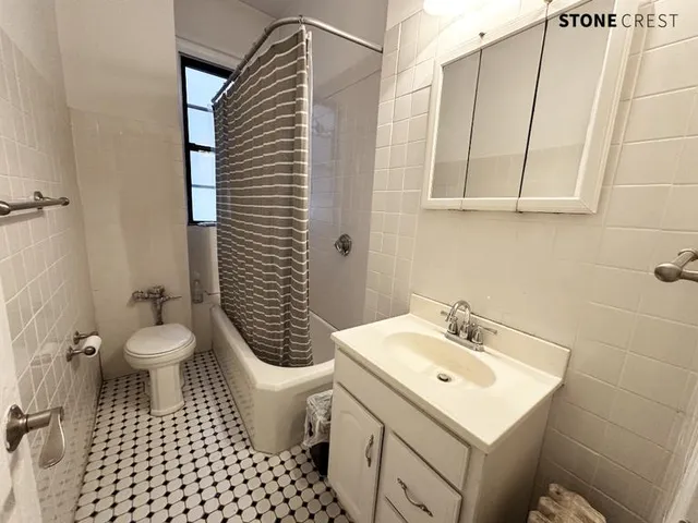 a bathroom with a sink a toilet a mirror and shower
