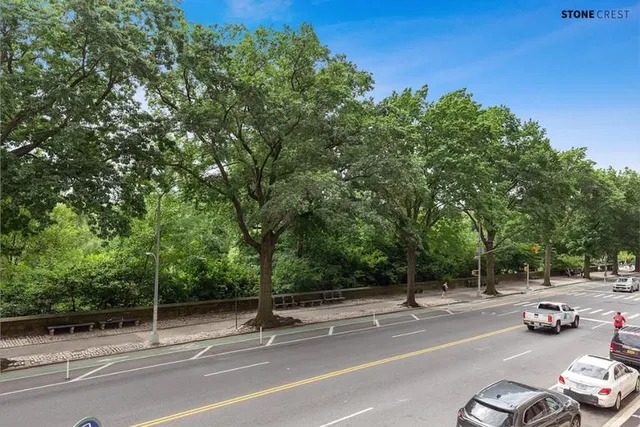 a view of a city street with a car parked on the road