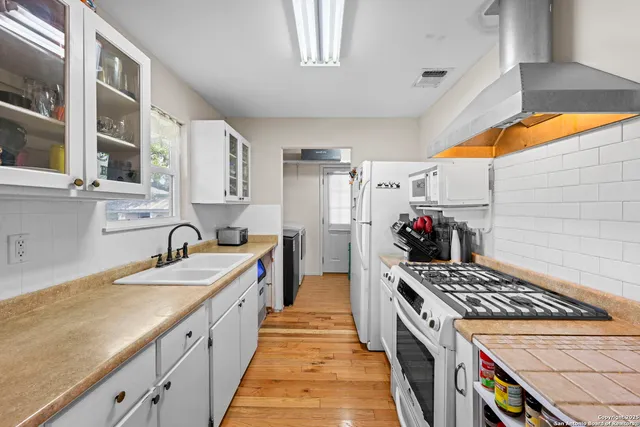 a large kitchen with a stove and a sink