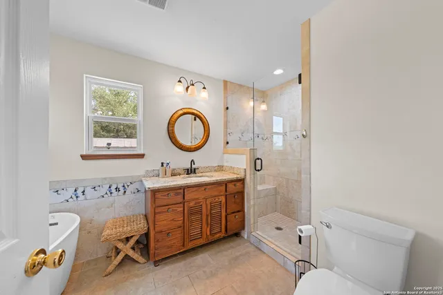 a spacious bathroom with a toilet a sink and a mirror