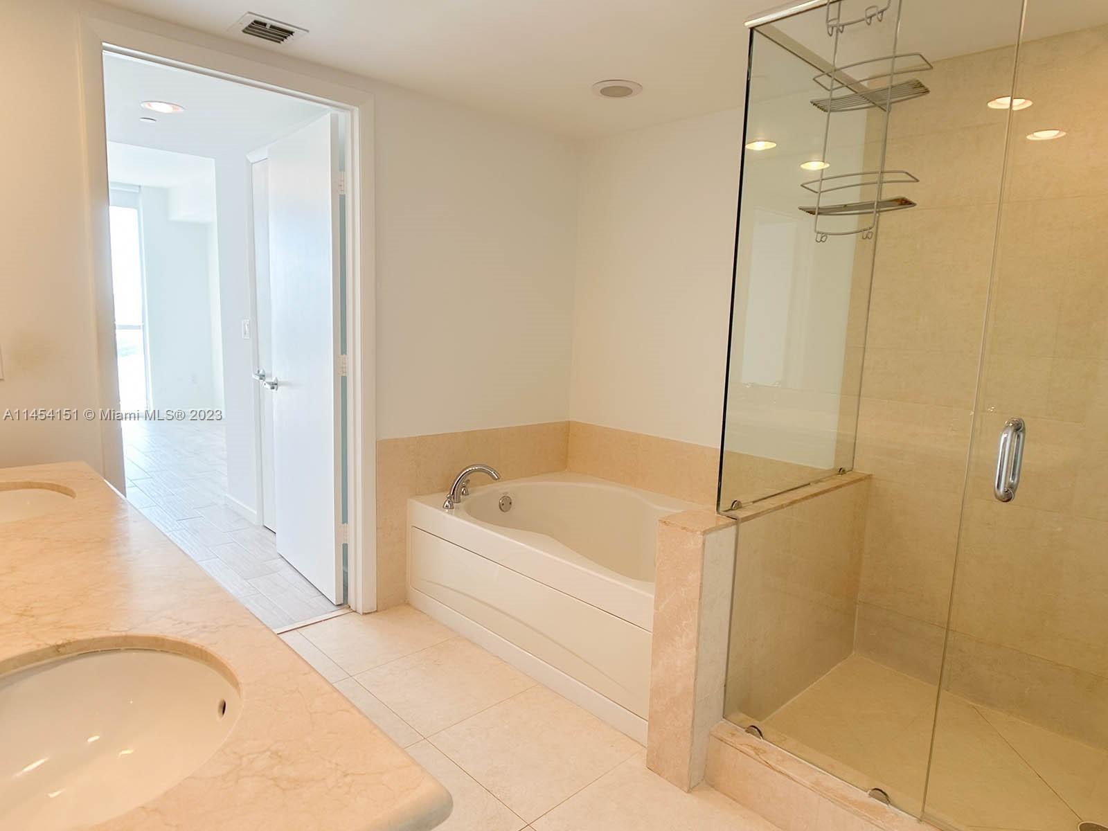 50 Biscayne Boulevard, Unit 3104 Miami, FL 33132 - Photo 21 of 52 a bathroom with a bathtub and a shower