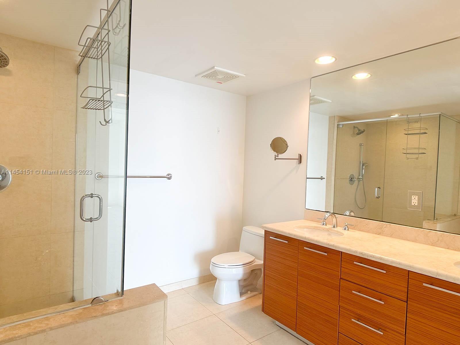 50 Biscayne Boulevard, Unit 3104 Miami, FL 33132 - Photo 24 of 52 a bathroom with a granite countertop sink a toilet and shower
