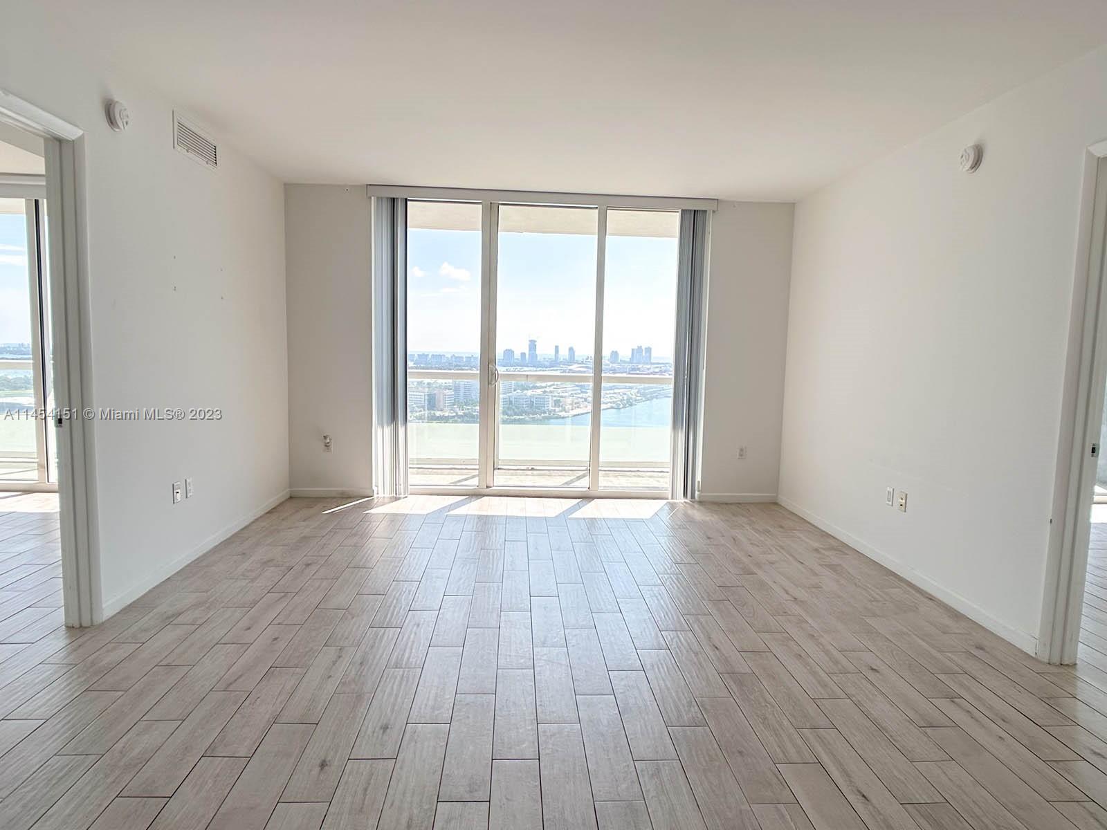 50 Biscayne Boulevard, Unit 3104 Miami, FL 33132 - Photo 6 of 52 wooden floor in an empty room with a window