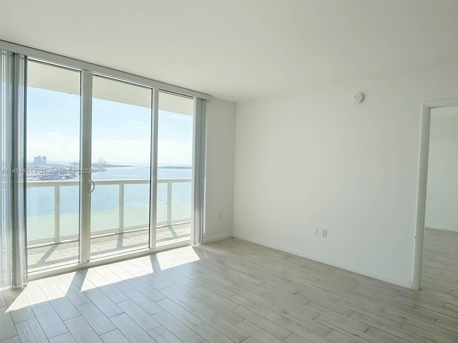 50 Biscayne Boulevard, Unit 3104 Miami, FL 33132 - Photo 7 of 52 a view of an empty room with wooden floor and a window