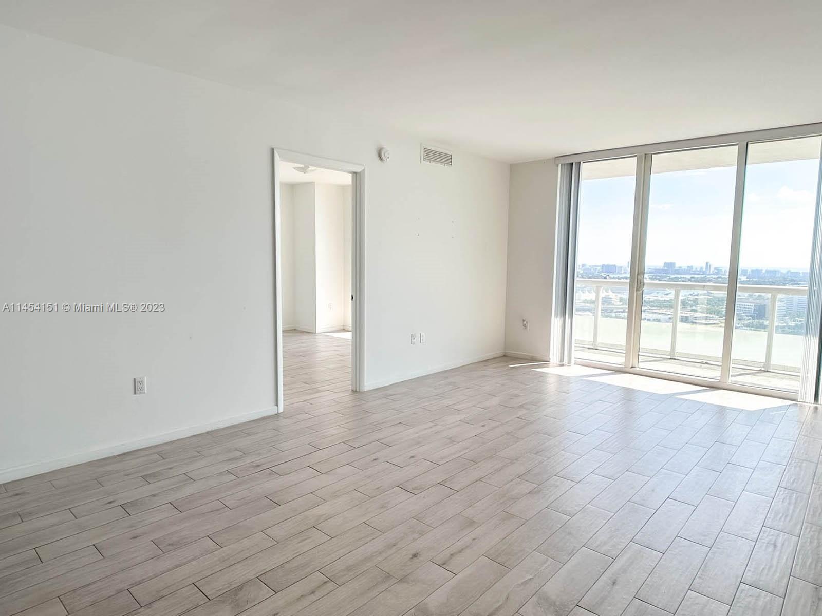 50 Biscayne Boulevard, Unit 3104 Miami, FL 33132 - Photo 8 of 52 wooden floor in an empty room with a window