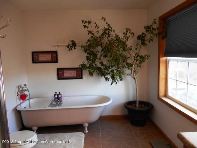 805 Randolph Avenue Rifle, CO 81650 - Photo 13 of 20 a white bath tub sitting in a bathroom next to a window