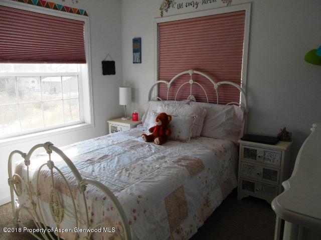 805 Randolph Avenue Rifle, CO 81650 - Photo 15 of 20 a bedroom with a bed next to a window with outer view