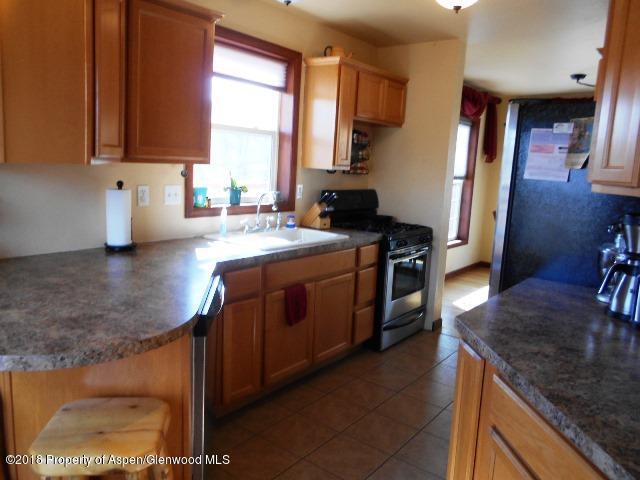 805 Randolph Avenue Rifle, CO 81650 - Photo 5 of 20 a kitchen with stainless steel appliances granite countertop a sink stove and refrigerator