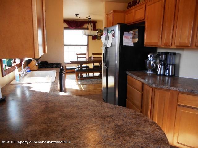 805 Randolph Avenue Rifle, CO 81650 - Photo 6 of 20 a kitchen with stainless steel appliances granite countertop a refrigerator a stove and a sink with granite countertops
