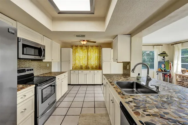 a kitchen with stainless steel appliances granite countertop a stove a sink and a microwave