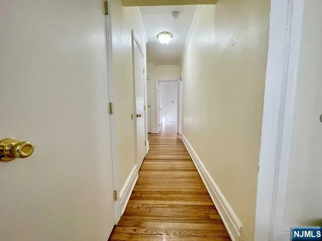 a view of a hallway with wooden floor