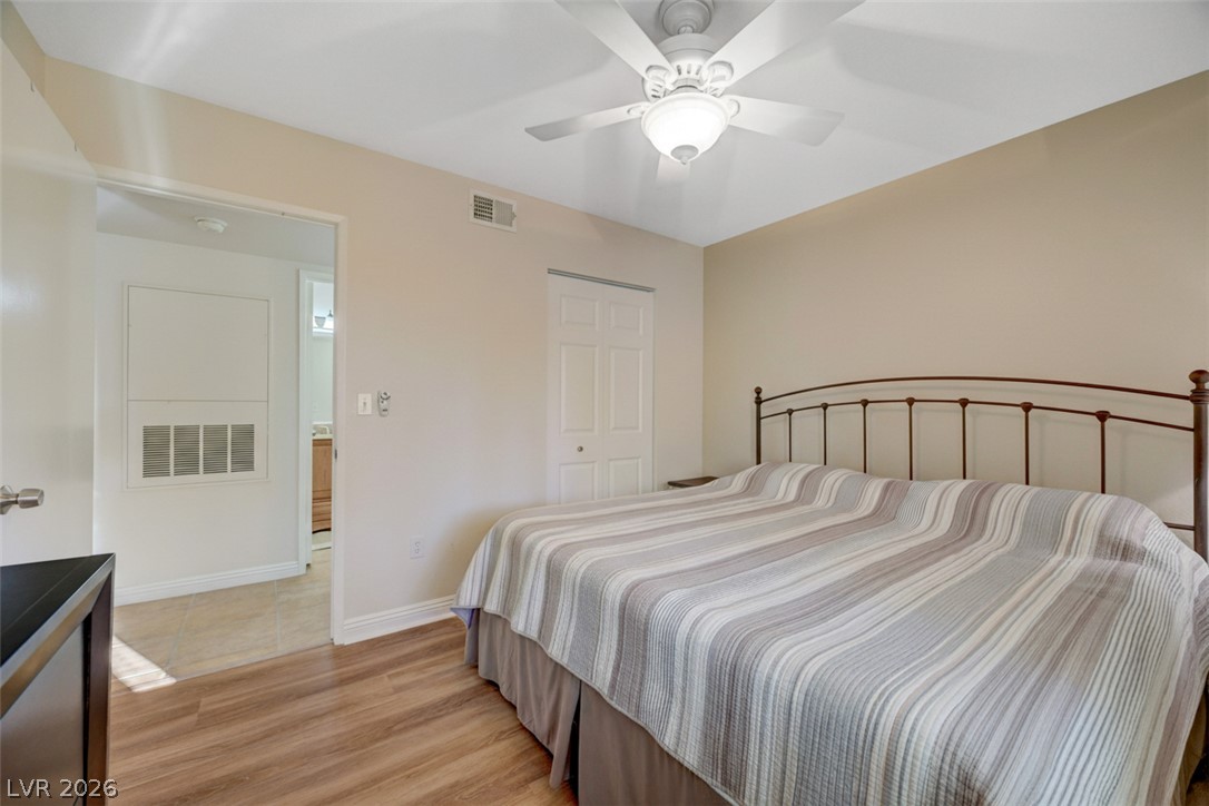 7885 West Flamingo Road, Unit 1071 Las Vegas, NV 89147 - Photo 18 of 28 Relax in this well-lit bedroom featuring rich wood flooring and a refreshing ceiling fan.