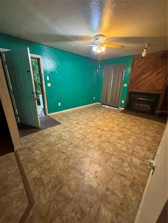 an empty room with closet and a ceiling fan