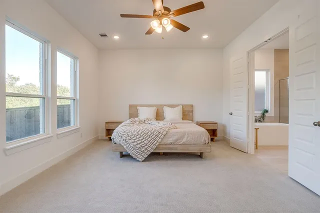 a spacious bedroom with a bed and a large window