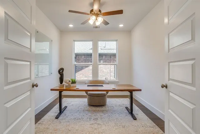 a view of a workspace with furniture and a window