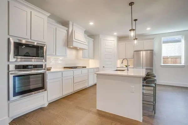 a kitchen with a sink stainless steel appliances and cabinets