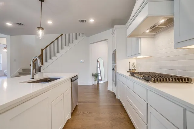 a kitchen with white cabinets and appliances