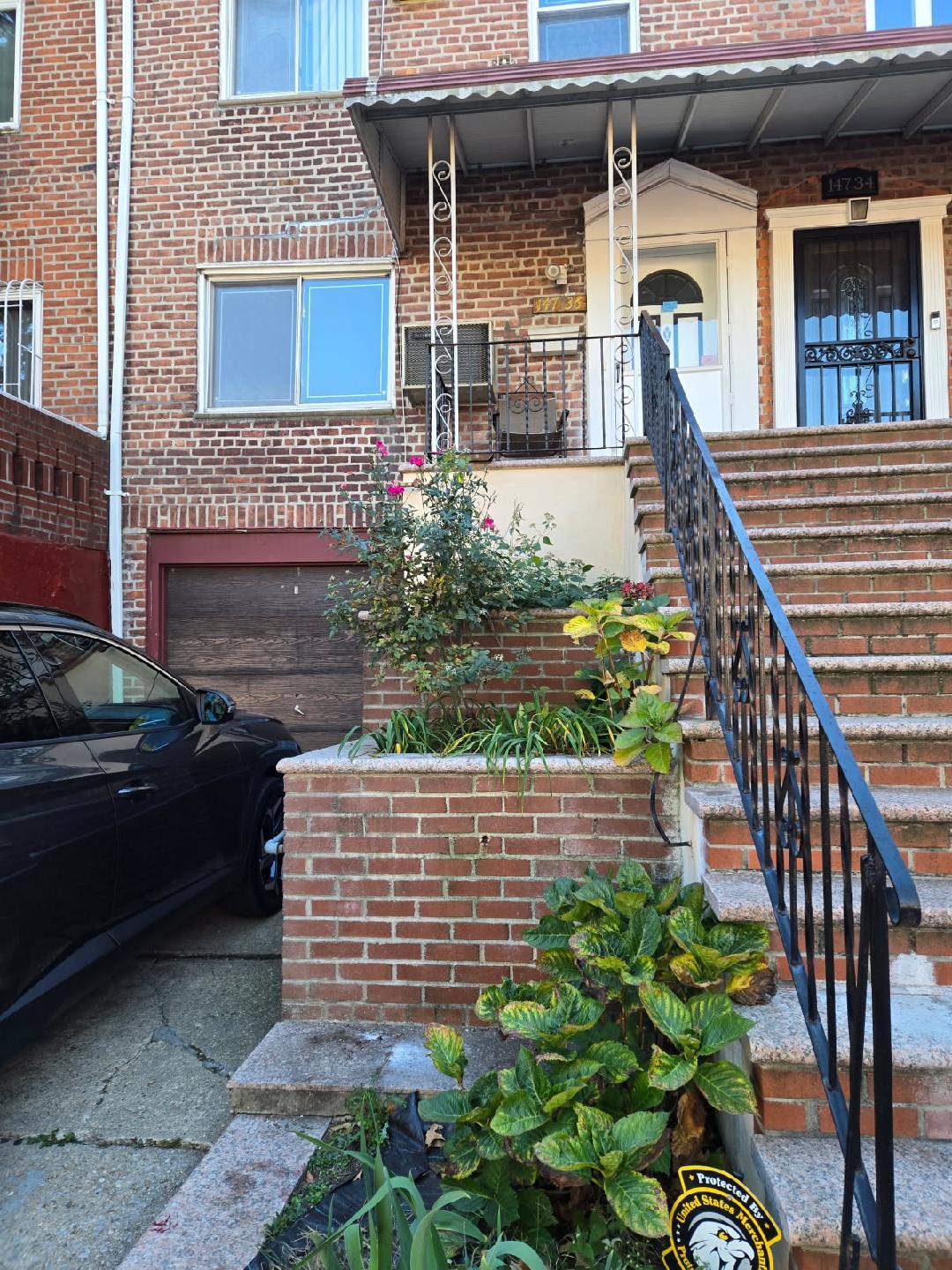 147-36 77th Road Queens, NY 11367 - Photo 1 of 1 Entrance to property with brick siding and an attached garage