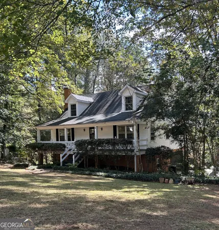 a view of a house next to a big yard and large trees