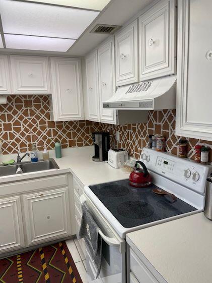 2500 Presidential Way, Unit 405 West Palm Beach, FL 33401 - Photo 15 of 28 a kitchen with white cabinets and sink