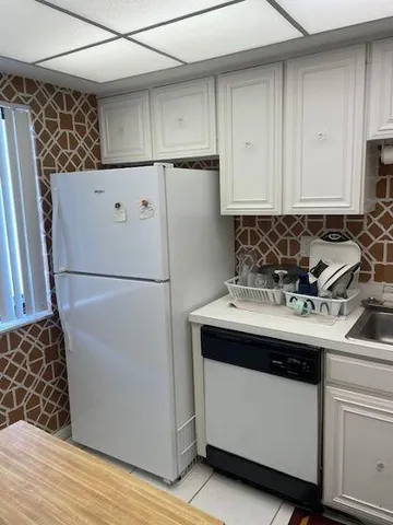 a white refrigerator freezer sitting inside of a kitchen