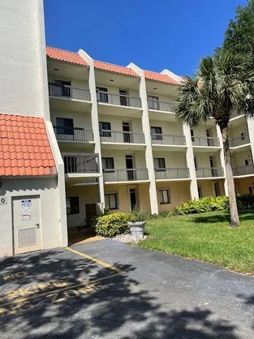 a front view of a building with a garden