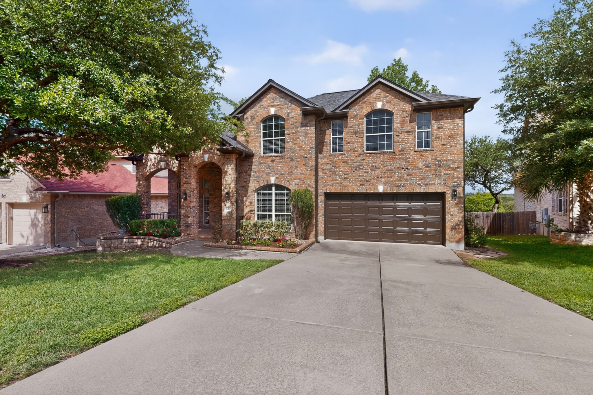 8617 Cobblestone Austin, TX 78735 - Photo 2 of 37 A timeless brick exterior, dramatic arched entryway, covered front porch, and professionally manicured landscaping create an elegant first impression and a warm welcome home.