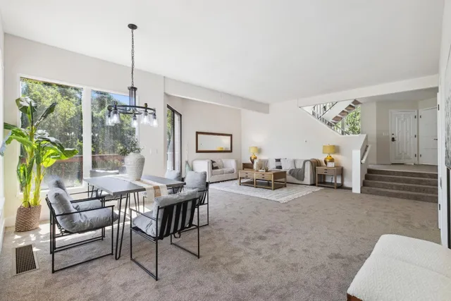 a view of a livingroom with furniture and floor to ceiling window