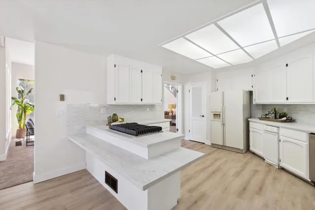 a kitchen with stainless steel appliances granite countertop a stove a sink and a refrigerator