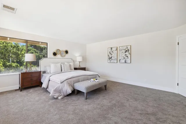 a spacious bedroom with a bed and a large window