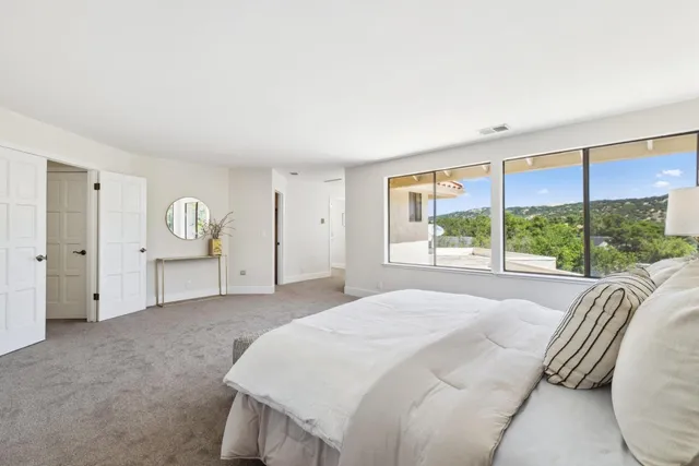 a spacious bedroom with a bed and large window