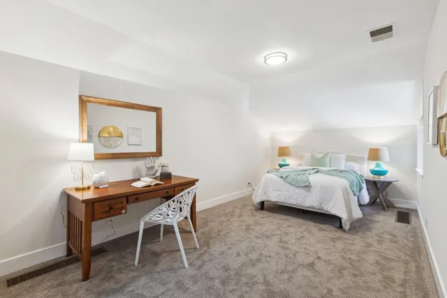 a bedroom with a bed and a painting on the wall