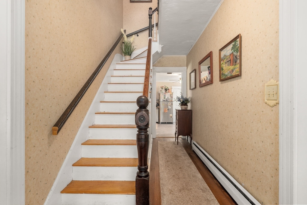 130 Tower Road Lincoln, MA 01773 - Photo 12 of 21 a view of staircase with lots of frames on wall and a window