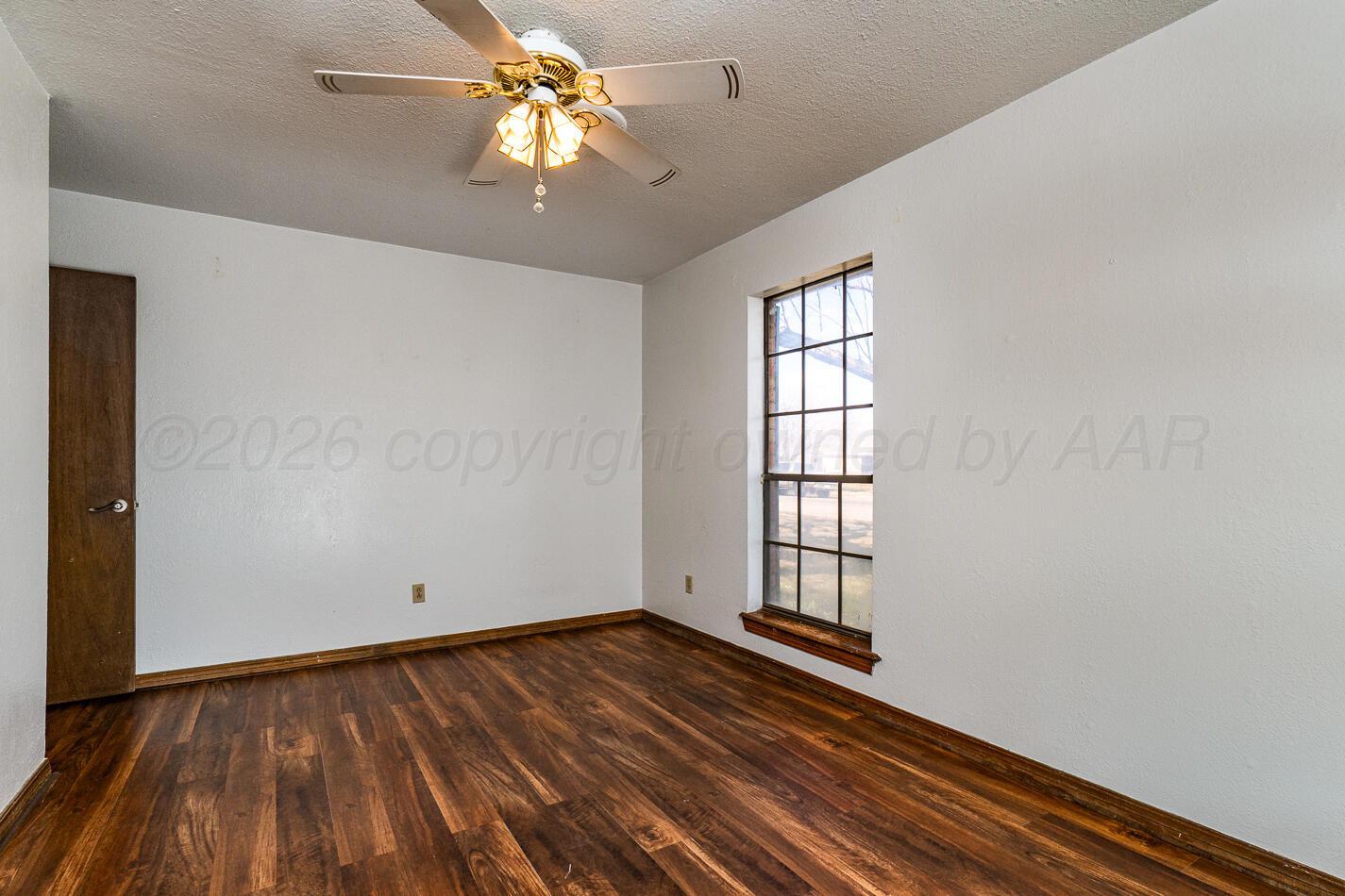7803 Farrell Drive Amarillo, TX 79121 - Photo 13 of 29 wooden floor in an empty room with a window